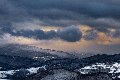 Scenic view of snowcapped mountains against dramatic sky