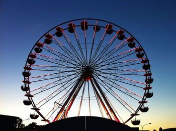 Low angle view of ferris wheel against blue sky