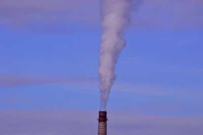 Smoke emitting from chimney against sky