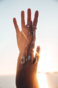 Cropped image of hands against sky