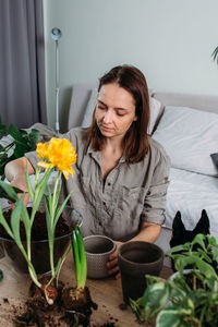 Young woman is transplanting houseplant. spring fertilizer for home flowers