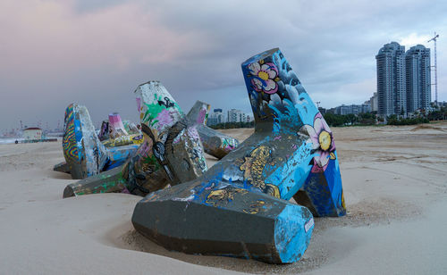 Low angle view of sculptures  on beach against sky