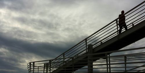 Low angle view of bridge against cloudy sky