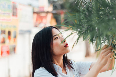 Portrait of young woman looking away outdoors