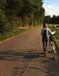 Rear view of woman walking on road