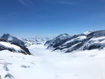 Scenic view of snowcapped mountains against blue sky