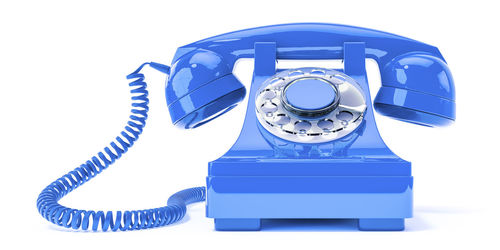 Close-up of blue telephone on white background