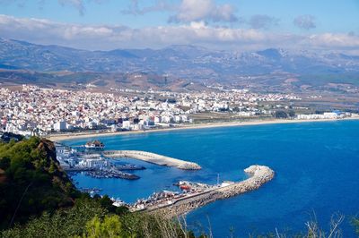 High angle view of bay and cityscape against sky