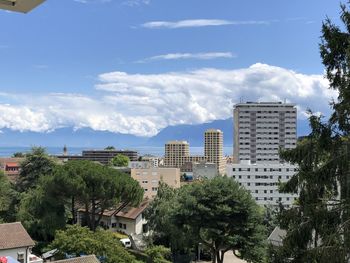Trees and buildings against blue sky