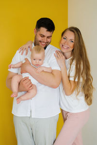 Beautiful happy young family with a baby boy in their arms