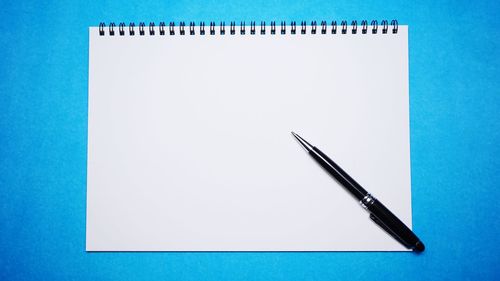 High angle view of pen on table against blue background