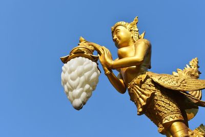 Low angle view of statue against blue sky