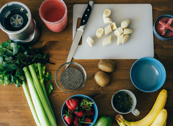 Different fruits and berries and seeds on the kitchen table for a delicious healthy dessert. 