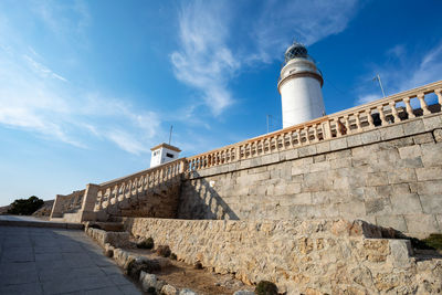 Lighthouse by sea against sky