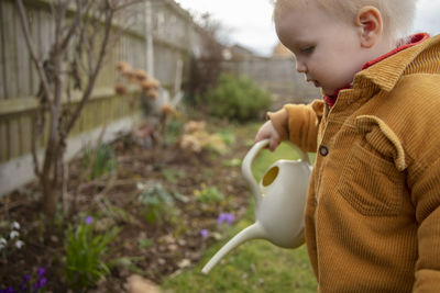 Side view of boy drinking outdoors