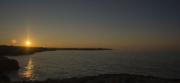 Scenic view of sea against clear sky during sunset