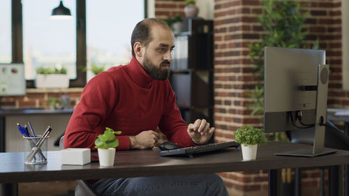 Portrait of young man using laptop while sitting on table