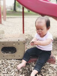 Full length of cute baby girl sitting outdoors