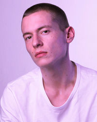 Portrait of young man against pink background
