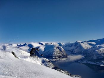 Scenic view of snowcapped mountains against clear blue sky