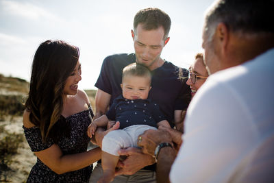 Family smiles as dad holds baby