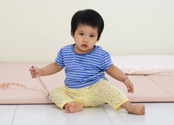 Portrait of cute girl sitting on floor at home