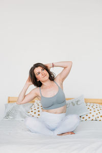 Young woman sitting on bed