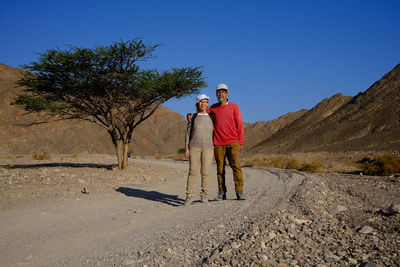 Senior couple standing at desert against clear blue sky