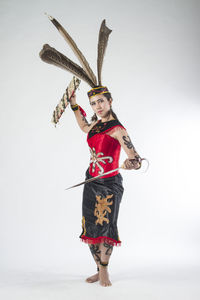 Portrait of young woman wearing mask against white background