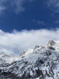 Low angle view of snowcapped mountains against sky