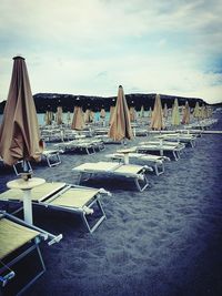 Chairs on beach against sky