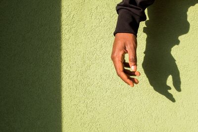 Midsection of man with shadow on hand