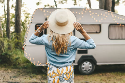 Asian woman traveling relaxing and playing guitar on a road trip in nature in the forest