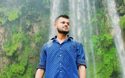 Portrait of young man looking away in forest