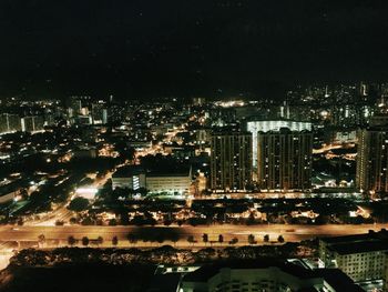 Illuminated cityscape against sky at night