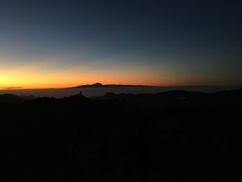 Silhouette landscape against clear sky during sunset