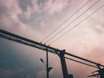 Low angle view of silhouette electricity pylon against sky