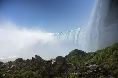 Low angle view of waterfall against sky