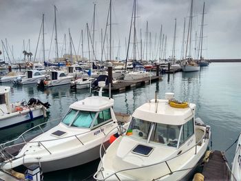 Boats moored in a marina in a rainy day