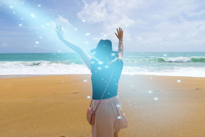 Rear view of person standing at beach against sky