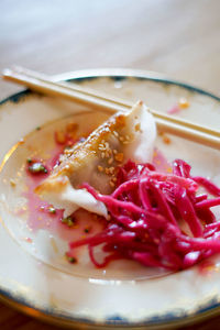 Close-up of jiaozi with red cabbage in plate on table