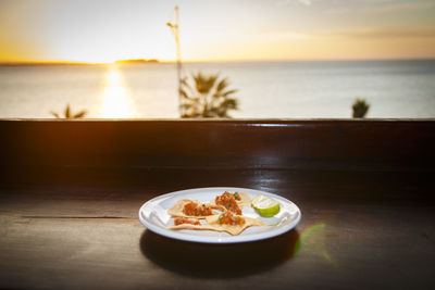 Food in plate on table against sea