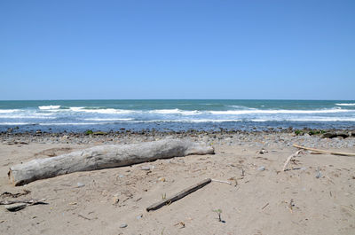 Scenic view of beach against clear blue sky