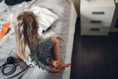 Rear view of woman relaxing on bed