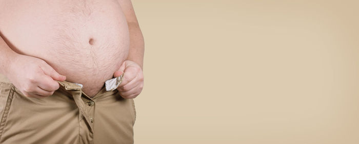 Close-up of man holding hands against white background