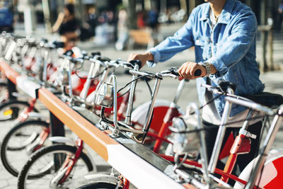 Midsection of man renting bicycle on street