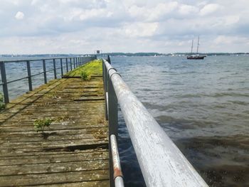 Old pier over sea against sky