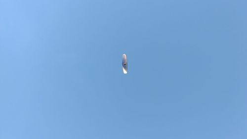 Low angle view of bird flying against clear blue sky