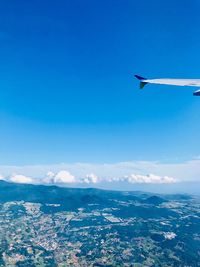 Airplane flying over sea against blue sky