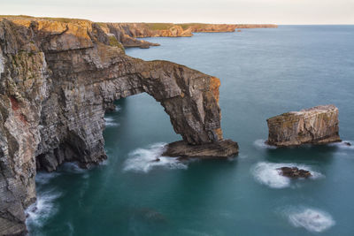 Scenic view of rock formation in sea against sky